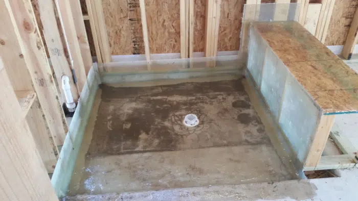 Rectangular shower pan with membrane turned up the walls and a capped center drain